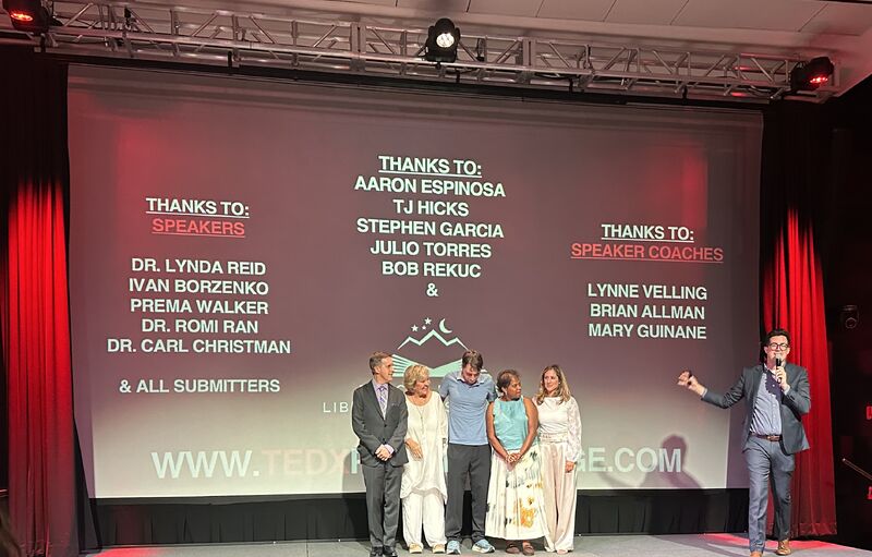 The speakers and organizers gathered onstage at TEDx Rancho Mirage beneath a screen thanking the event contributors.